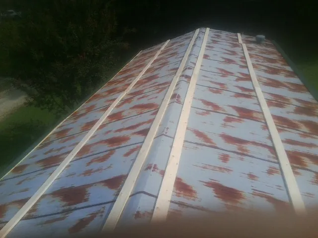 Rusted metal roof panels with new wood purlins before replacement — Storm Damage Roof Repair in Avery Island by Roofing Brothers