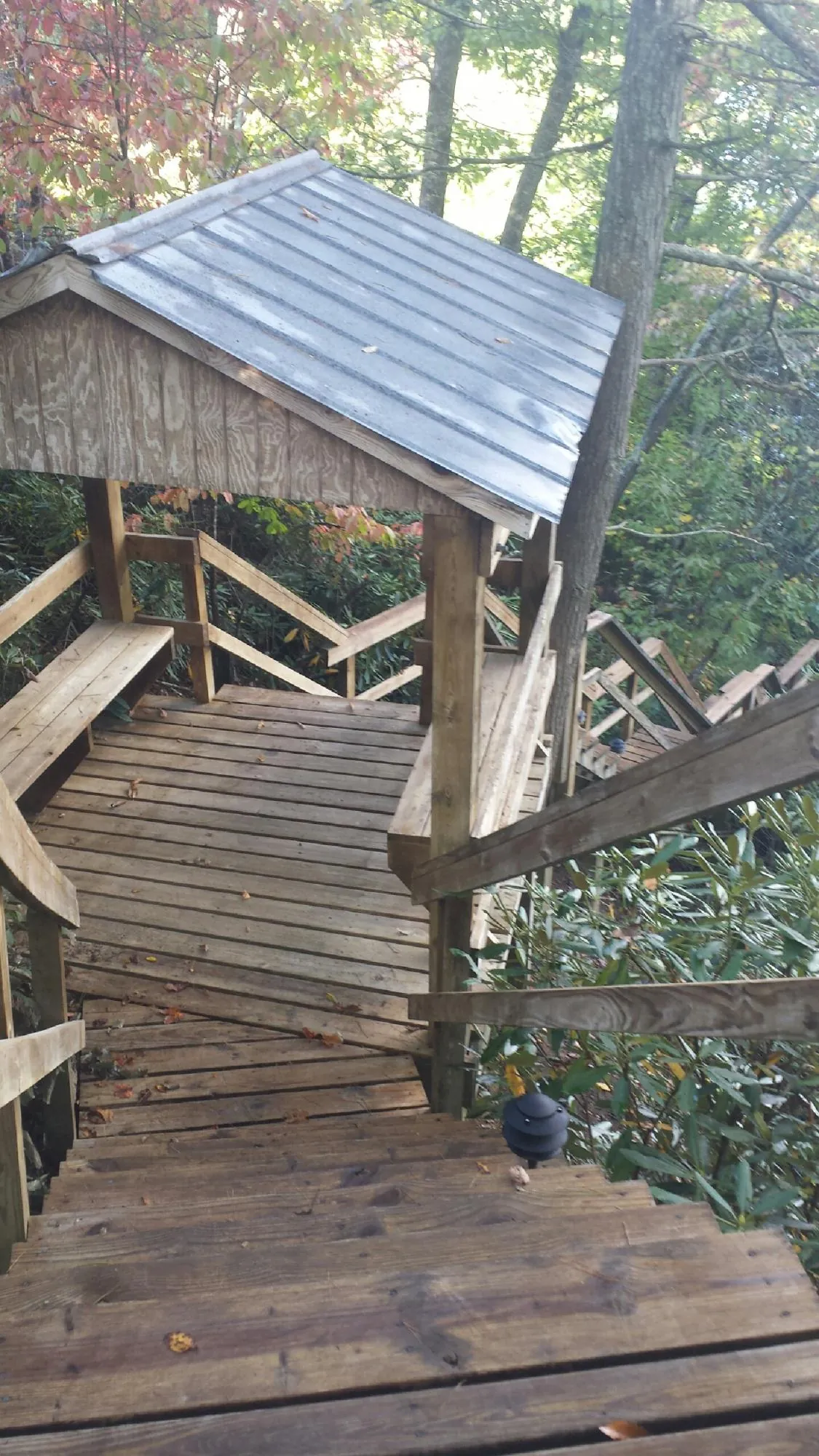 Metal roofed shelter over wooden steps on a wooded walkway — Skylight Repair & Installation work by our crew in Avery Island