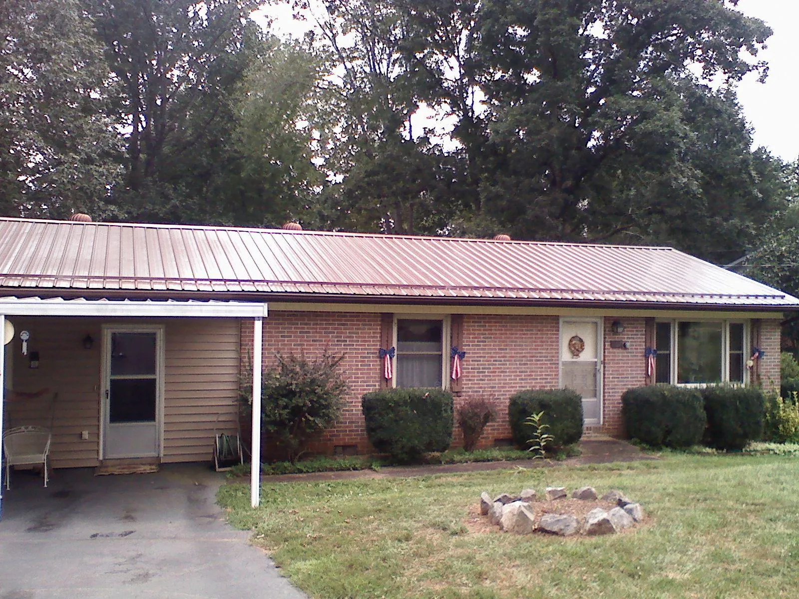 Bronze metal roof and carport on a brick ranch home — Roof Repair work by our crew in Avery Island