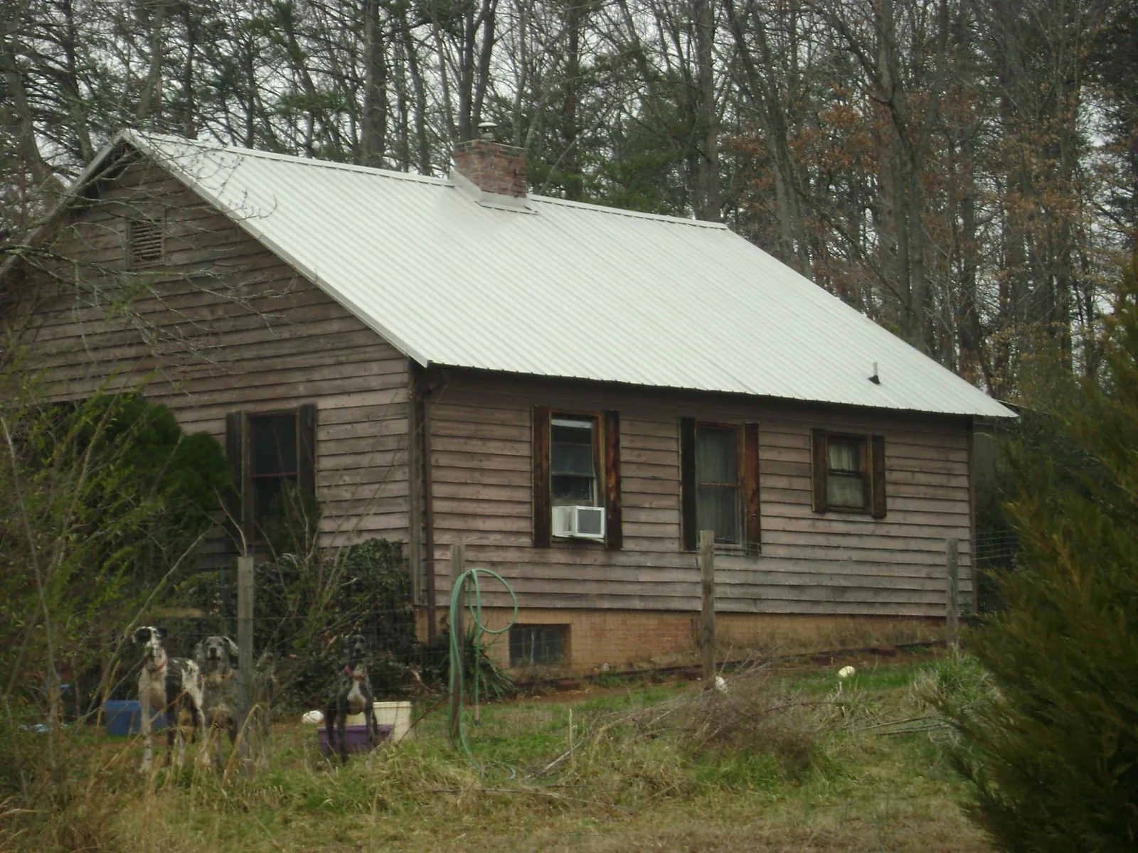 White metal roof on an old wood sided farmhouse, from a Metal Roof Installation job in Avery Island